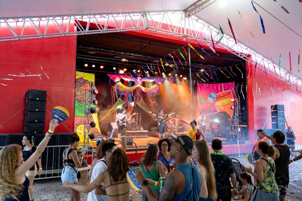 diversas pessoas em frente a um palco celebrando o Carnaval