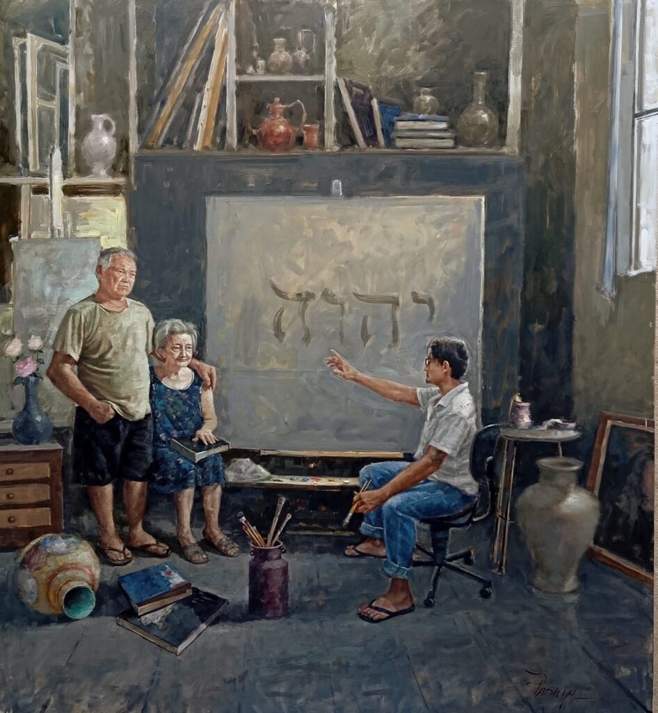 A imagem é uma pintura a óleo que retrata um artista pintando um quadro com letras hebraicas. O artista está sentado numa cadeira, com as costas viradas para o espectador, e a apontar para o quadro. Ao seu lado, estão um casal de idosos, que parecem ser os modelos do artista. O estúdio de arte é bem decorado com vários objetos, incluindo vasos, livros e quadros. O esquema de cores é predominantemente escuro e terroso, com toques de cor nos objetos e nas roupas dos modelos. A pintura é rica em detalhes e tem uma textura visível. O estilo é realista, com atenção aos detalhes e à composição. A iluminação é suave e difusa, criando uma atmosfera serena e contemplativa.