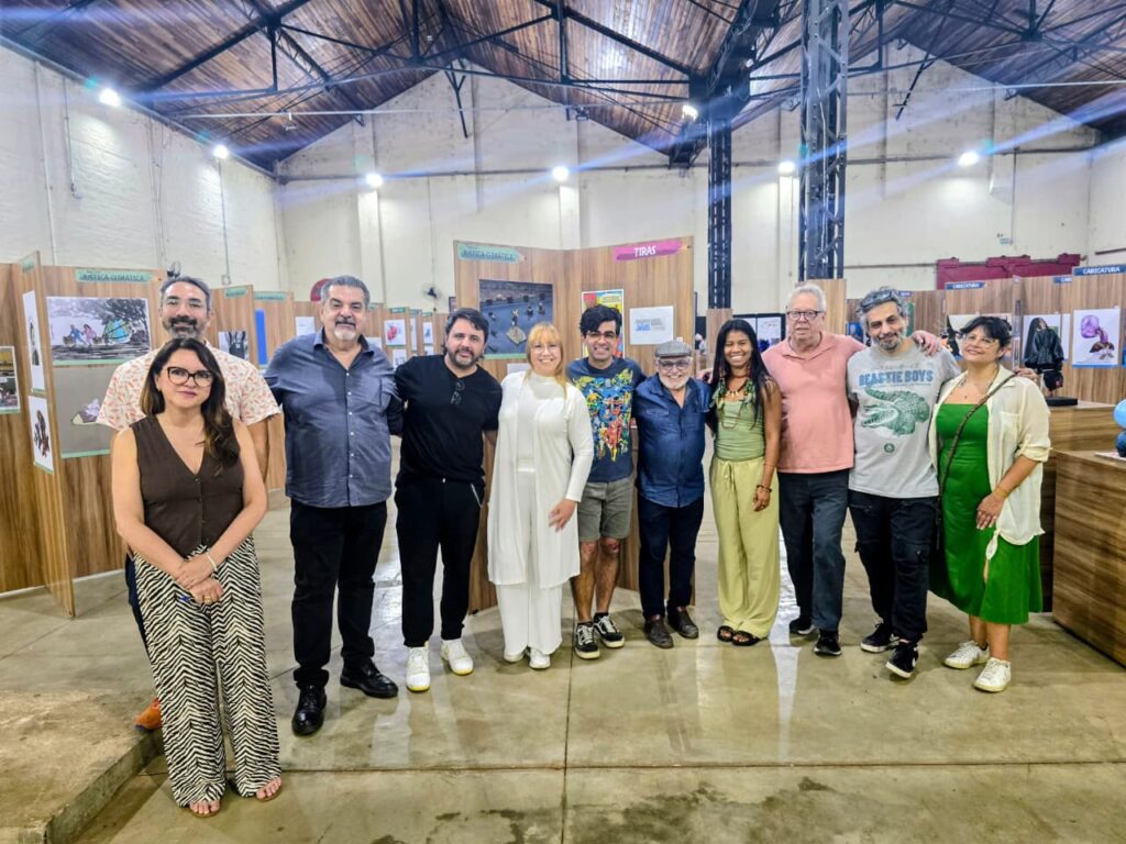 Foto coletiva do júri e organizadores posando juntos na exposição do Salão de Humor.