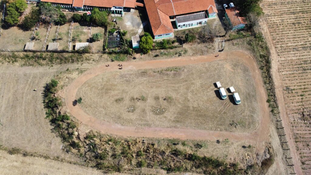 A imagem aérea mostra um complexo de edifícios com telhados vermelhos, possivelmente uma escola ou centro de treinamento.
