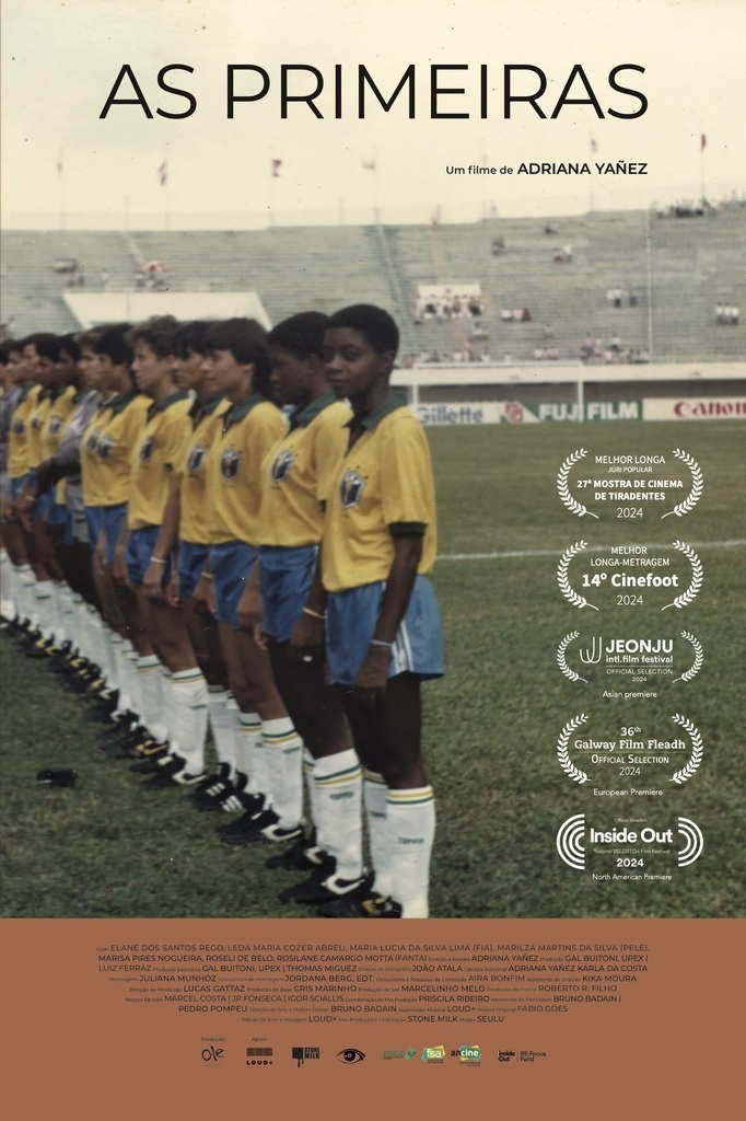 A imagem é um pôster de filme intitulado "AS PRIMEIRAS", dirigido por Adriana Yañez. O pôster apresenta uma fotografia de uma equipe de futebol feminino, composta por jovens jogadoras em uniforme amarelo e azul, alinhadas em campo com um estádio ao fundo. No lado direito do pôster, há uma série de selos de premiações e seleções em festivais de cinema, incluindo "MELHOR LONGA JURI POPULAR 27ª MOSTRA DE CINEMA DE TIRADENTES 2024", "MELHOR LONGA-METRAGEM 14° Cinefoot 2024", "JEONJU intl.film festival OFFICIAL SELECTION 2024 Asian premiere", "36th Galway Film Fleadh OFFICIAL SELECTION 2024 European Premiere" e "Inside Out 2024 North American Premiere". Na parte inferior do pôster, há uma lista extensa de nomes, que provavelmente se refere ao elenco e à equipe de produção do filme. Abaixo dessa lista, encontram-se os logotipos de algumas empresas e organizações, como "ole", "LOUD+", "STONE MILK", "isa" e "ancine". A estética geral do pôster remete a uma produção cinematográfica com foco em documentário ou drama esportivo.