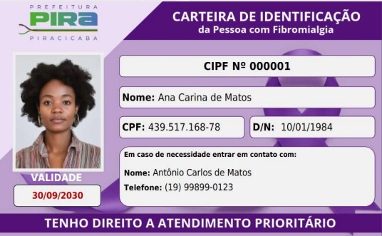 A imagem é uma carteira de identificação para pessoas com fibromialgia, emitida pela Prefeitura de Piracicaba. A carteira apresenta: * *Foto:* Uma foto 3x4 da titular. * *Título:* "CARTEIRA DE IDENTIFICAÇÃO da Pessoa com Fibromialgia". * *Número da Carteira:* CIPF Nº 000001. * *Nome da Titular:* Ana Carina de Matos. * *CPF:* 439.517.168-78. * *Data de Nascimento:* 10/01/1984. * *Validade:* 30/09/2030. * *Contato em Caso de Necessidade:* Nome: Antônio Carlos de Matos, Telefone: (19) 99899-0123. * *Rodapé:* "TENHO DIREITO A ATENDIMENTO PRIORITÁRIO". A identidade possui um fundo roxo com uma fita roxa estilizada, símbolo comum de conscientização sobre fibromialgia.