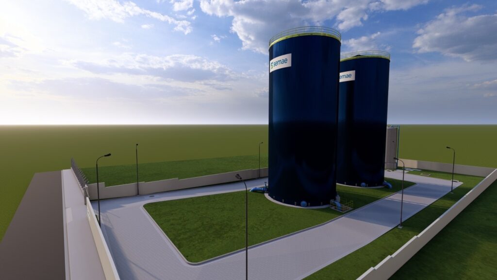 A imagem apresenta um render 3D de uma estação de tratamento de água ou reservatório, com duas grandes torres cilíndricas escuras em destaque. As torres possuem uma borda amarela no topo e o logotipo "semae" em branco em uma das laterais. Ao redor das torres, há uma área cercada por um muro baixo branco e uma cerca com arame farpado no topo em algumas seções. O terreno dentro da área é composto por gramados verdes bem cuidados, caminhos pavimentados com um padrão de mosaico e postes de iluminação pública. Ao fundo, o céu é azul com nuvens brancas e fofas, e o horizonte se estende com uma paisagem plana e verde. A iluminação sugere um dia claro, possivelmente ao amanhecer ou entardecer, com um brilho suave no céu. A perspectiva da imagem é de um ponto de vista ligeiramente elevado, oferecendo uma visão geral da instalação.