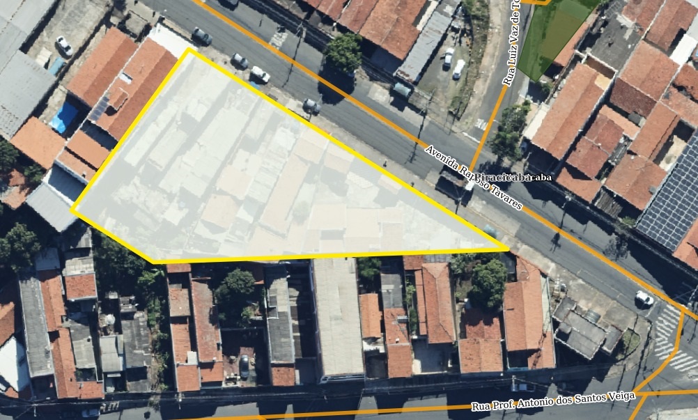 A imagem mostra uma vista aérea de um bairro residencial urbano, com um destaque em uma área triangular delimitada por uma borda amarela e preenchida com uma transparência branca. Essa área contém várias casas com telhados de cerâmica em tons de vermelho e laranja. A principal via que corta a imagem é a Avenida Raposo Tavares, uma avenida larga que segue em diagonal de cima para baixo na imagem. Outras ruas visíveis são a Rua Luiz Vaz de To (aparentemente abreviada) e a Rua Prof. Antonio dos Santos Veiga, que aparecem nas extremidades da imagem. As casas estão próximas umas das outras, formando um conjunto denso e compacto típico de áreas urbanas. Também é possível ver algumas árvores e veículos estacionados nas ruas, sugerindo um ambiente residencial ativo. A iluminação indica que a foto foi tirada durante o dia, com sombras bem definidas. A imagem parece ser de alta resolução, provavelmente capturada por satélite.