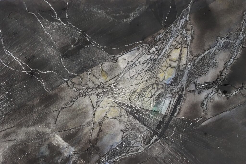 A imagem apresenta uma obra de arte abstrata em tons monocromáticos, predominando cinzas, pretos e brancos, com sutis toques de amarelo e azul. A composição é dinâmica, formada por linhas sinuosas e formas fragmentadas que criam uma sensação de movimento e profundidade. A textura é variada, mesclando áreas de pigmento escuro e liso com superfícies rugosas e granuladas, além de linhas delicadas que lembram fissuras, galhos ou veias. Também há padrões de hachuras que adicionam complexidade visual. A iluminação é dramática, com contrastes fortes entre luz e sombra, realçando as texturas. Não há figuras reconhecíveis, sugerindo um foco em formas orgânicas e geológicas, como raízes, formações rochosas ou estruturas celulares. A imagem transmite uma sensação de complexidade natural e abstrata.