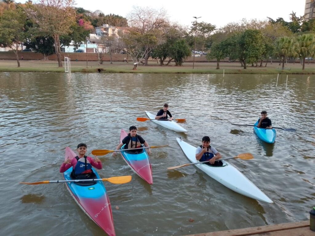 Imagem com alunos na lagoa com caiaques.