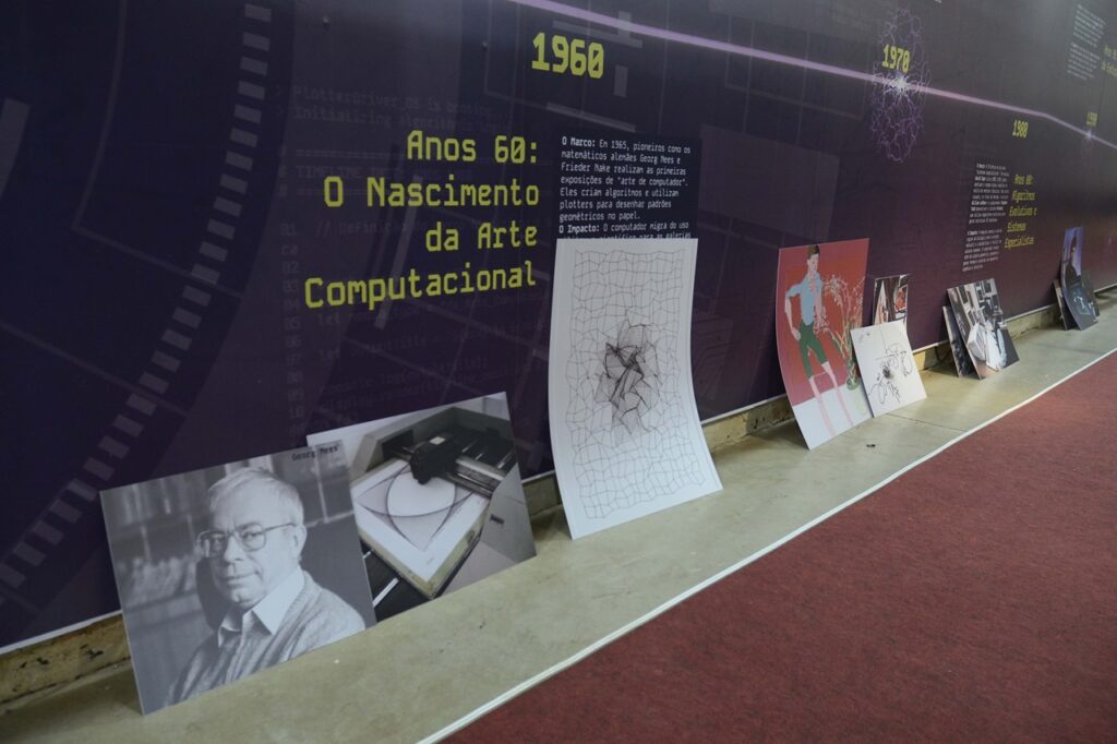 A imagem mostra uma exposição dedicada à arte computacional, com um painel cronológico que destaca os anos 1960 como o período do “Nascimento da Arte Computacional”. O texto explica que, em 1965, os matemáticos Georg Nees e Frieder Nake realizaram as primeiras exposições de arte gerada por computador, utilizando plotters para criar padrões geométricos por meio de algoritmos.