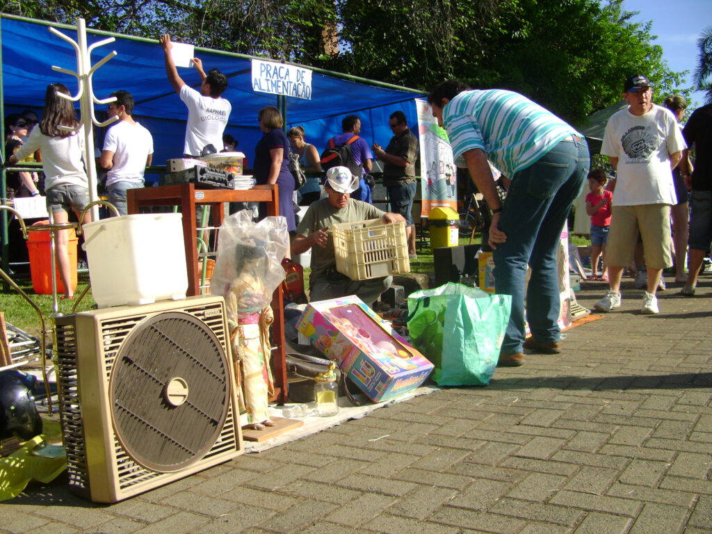 Feira de troca e reutilização reúne participantes e objetos usados em espaço ao ar livre.