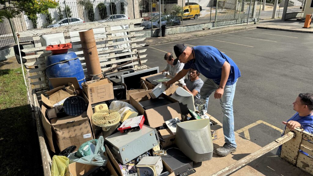 Trabalhadores separam e organizam diversos resíduos de equipamentos eletroeletrônicos para reciclagem.