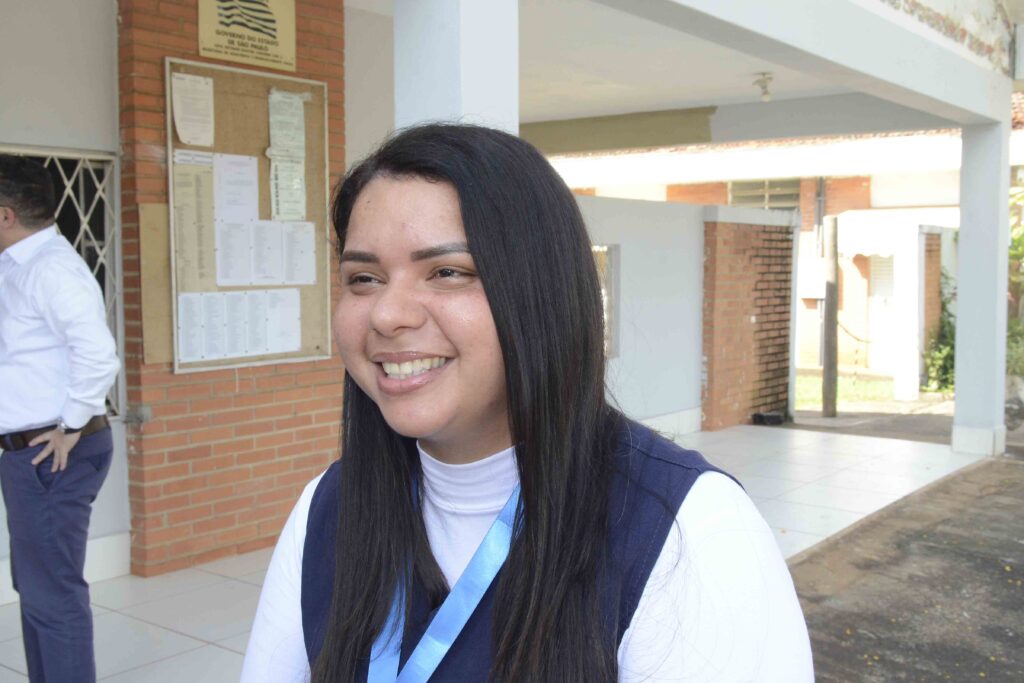 Cuidadora de idosos posa em área externa de instituição após receber reconhecimento por atuação em primeiros socorros.