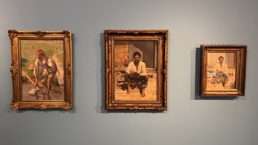 Obras de Almeida Júnior expostas em galeria mostram estudos e pinturas de personagens caipiras em molduras ornamentadas.