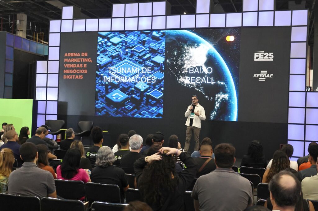 Palestrante apresenta conteúdo sobre marketing, vendas e negócios digitais para uma plateia durante um evento de empreendedorismo.