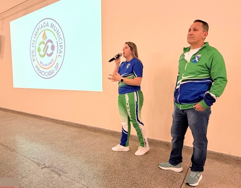 A imagem mostra dois representantes da Prefeitura de Piracicaba apresentando a XVIII Olimpíada Municipal da Melhor Idade.