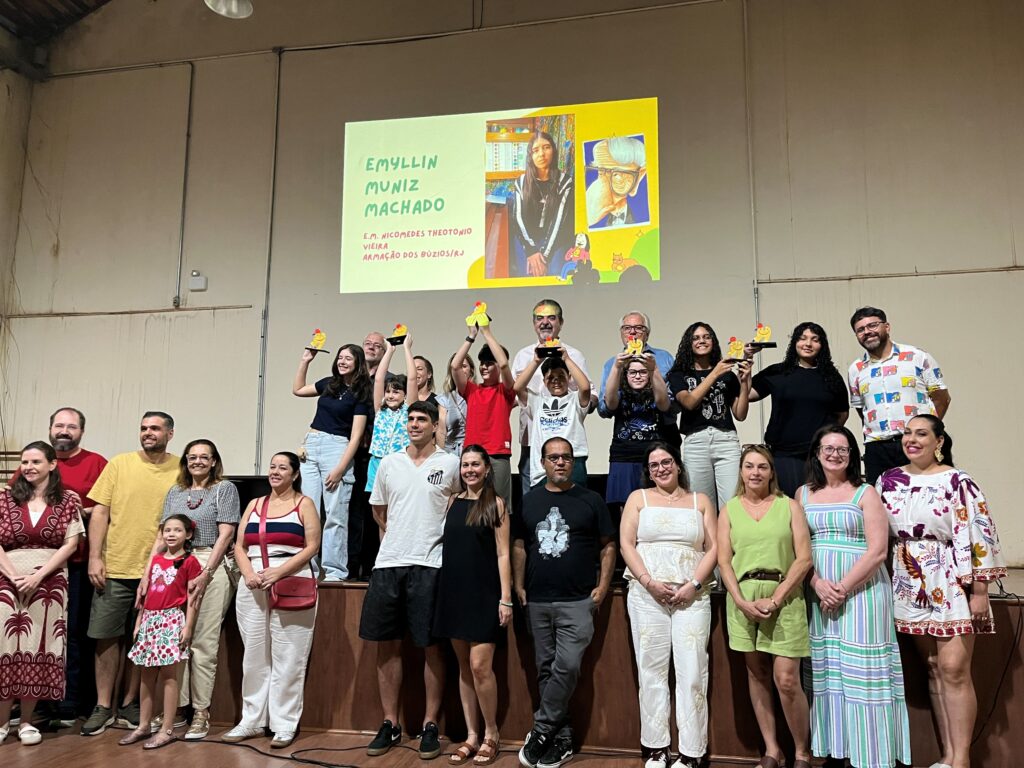 Todos os jovens premiados sobem ao palco e erguem orgulhosamente os seus troféus ao lado das autoridades e familiares.