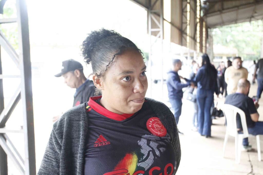 Retrato aproximado de uma mulher vestida com uma camisola desportiva e casaco num ambiente coberto.