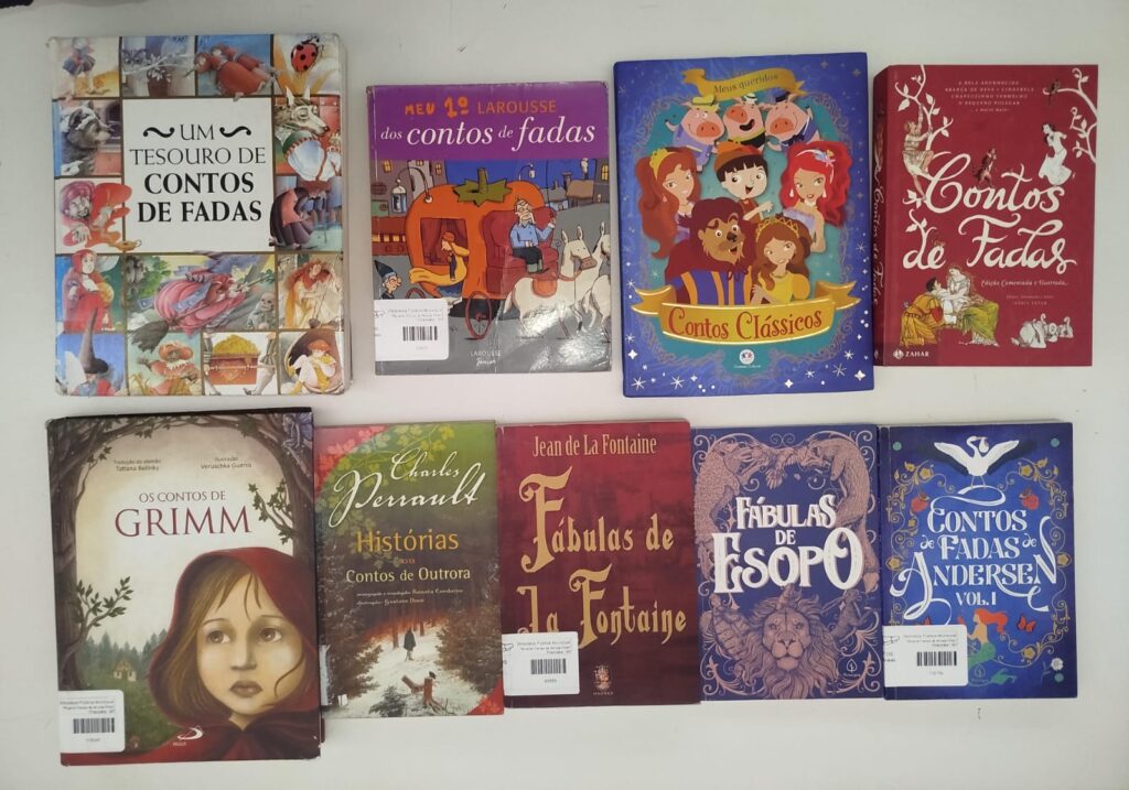 Nove livros de literatura infantil e fables dispostos organizadamente, com obras de autores como Irmãos Grimm, Charles Perrault, Jean de La Fontaine, Esopo e Hans Christian Andersen.