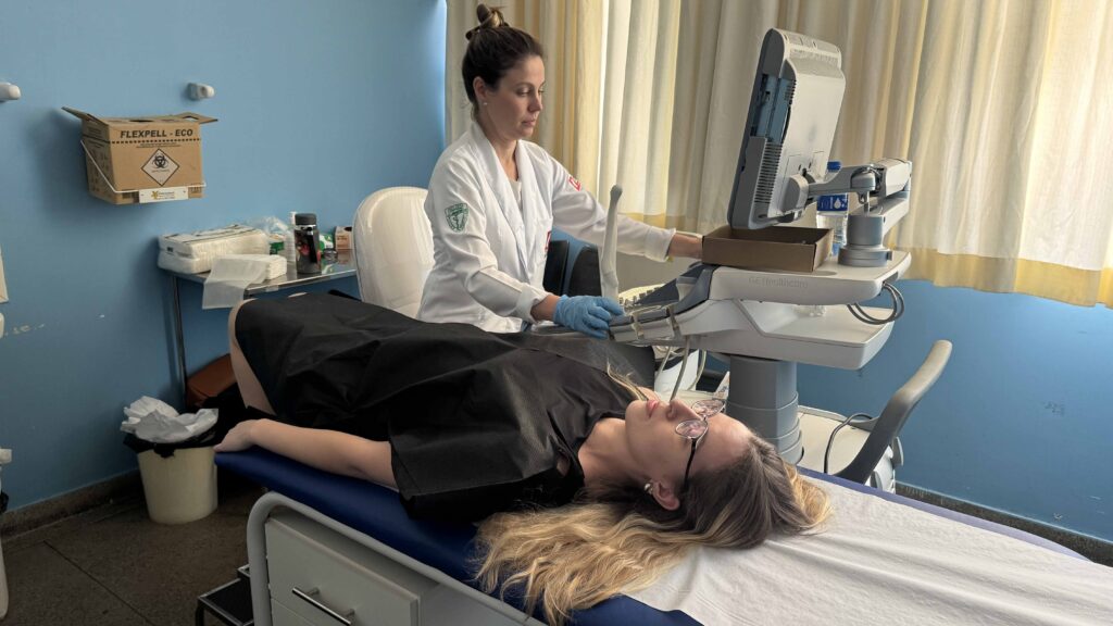 Uma médica a realizar um exame de ecografia (ultrassom) na paciente Luana Macena durante a ação do mutirão.