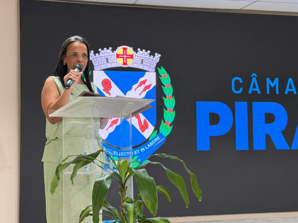 A diretora Marilu Romão discursa no púlpito em representação dos diretores de escola homenageados durante a cerimónia.