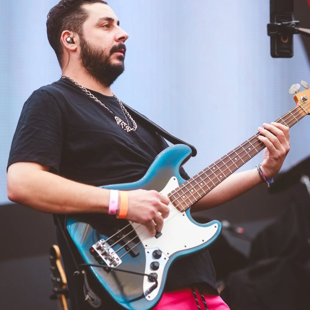O contrabaixista Leo Versolato toca o seu baixo elétrico azul num concerto.