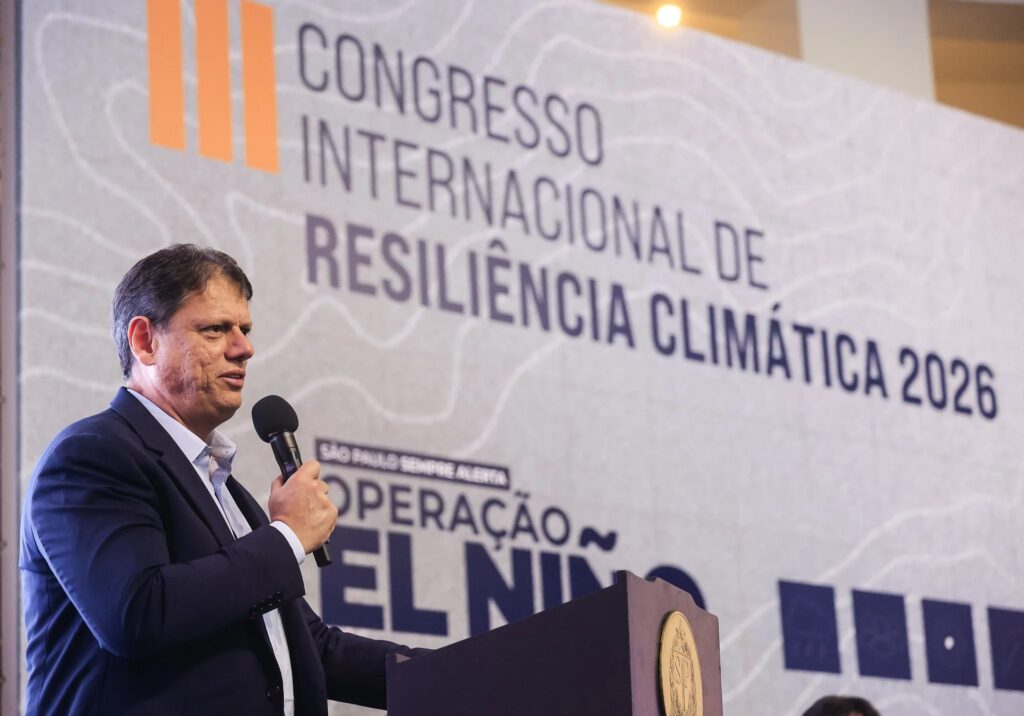 O governador do Estado de São Paulo, Tarcísio de Freitas, discursa num púlpito com microfone em riste durante o III Congresso Internacional de Resiliência Climática 2026.