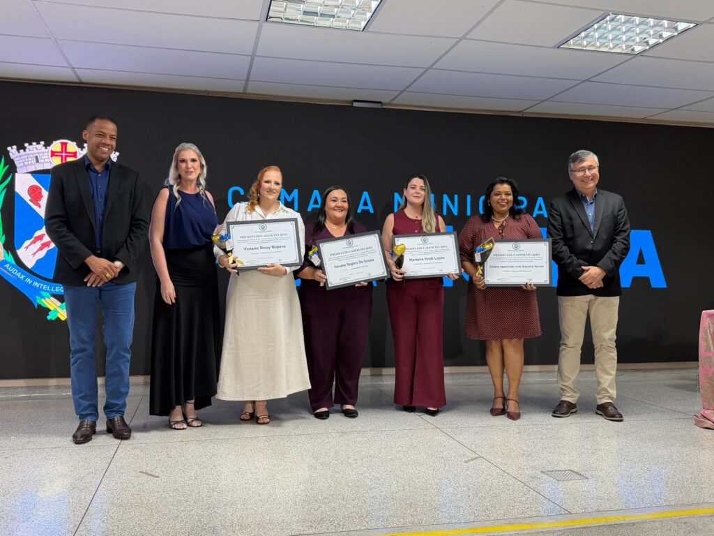 Professoras da categoria do Ensino Fundamental reunidas no palco a segurar os respetivos certificados do prémio juntamente com os organizadores.