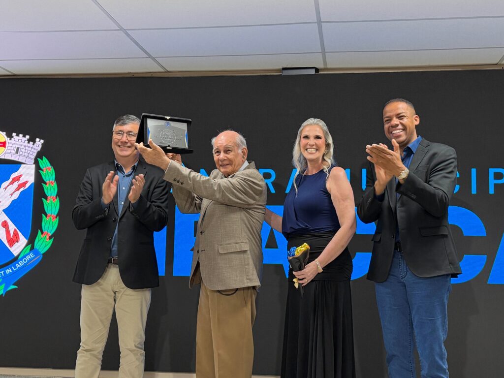 Homenagem especial ao professor sénior Miguel Morano Júnior (FOP/Unicamp), que exibe uma placa comemorativa prateada acompanhado pelas autoridades no palco.