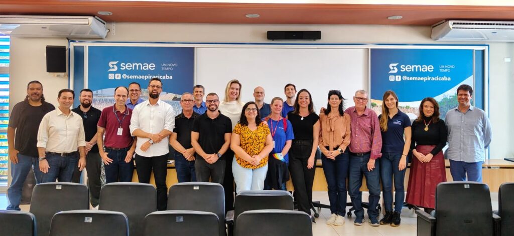 Servidores do Semae e membros da equipa técnica reunidos num auditório, posando para uma foto de grupo em frente a um painel institucional da autarquia durante a primeira reunião de elaboração do Plano Municipal de Segurança da Água (PMSA)