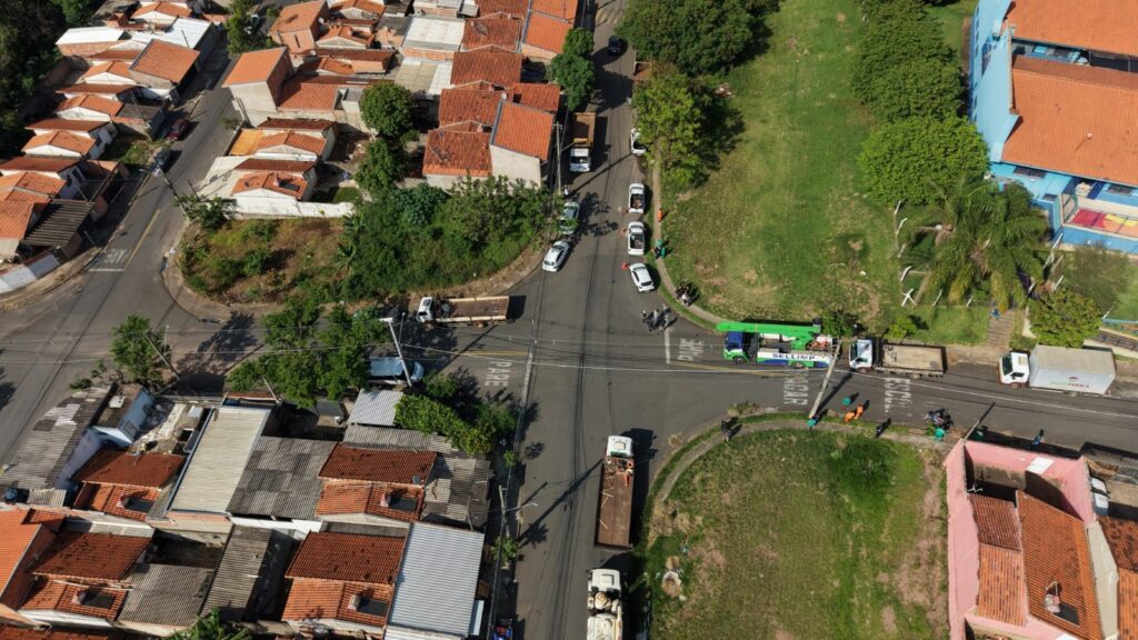 Uma perspetiva aérea que exibe o cruzamento de ruas no bairro, destacando a concentração de caminhões de serviço, veículos de apoio e trabalhadores atuando na região.